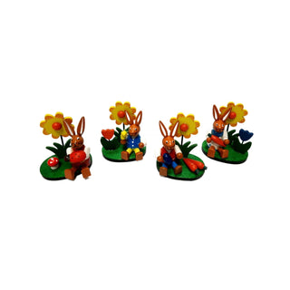 Farbenfrohes 4er-Set Osterhasen mit Blumen auf einem grünen Sockel