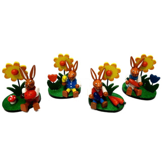 Farbenfrohes 4er-Set Osterhasen mit Blumen auf einem grünen Sockel