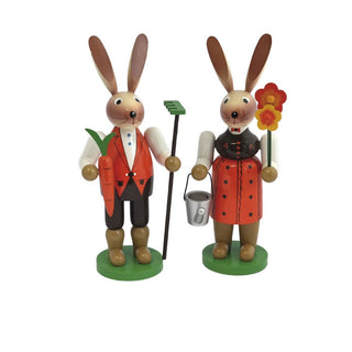 farbenfrohes Osterhasenpaar aus Holz im Gärtner-Motiv. Der Osterhase hält einen Rechen und eine Möhre in der Hand und die Häsin eine Gießkanne und einen Blumenstrauß.
