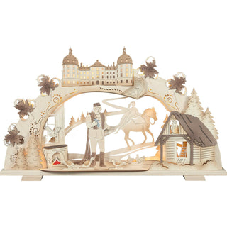 Auf dem elektrischen LED-Stripe-Schwibbogen ist das bekannte Wintermärchen vom Aschenbrödel dargestellt. Durch die Schattierungen werden detailgetreu Filmausschnitte gezeigt. Bis auf die rote Feuerstelle im Kamin und dem gefundenen blauen Schuh ist das Motiv naturfarben gestaltet. Der Prinz mit dem Schuh, die Prinzessin zu Pferd, das prunkvolle Schloss Moritzburg, die Tauben, die Eule Rosalie in ihrer Scheune und die drei Haselnüsse als Umrandung lassen den Märchenzauber unter Beleuchtung wirken. Bild 1.