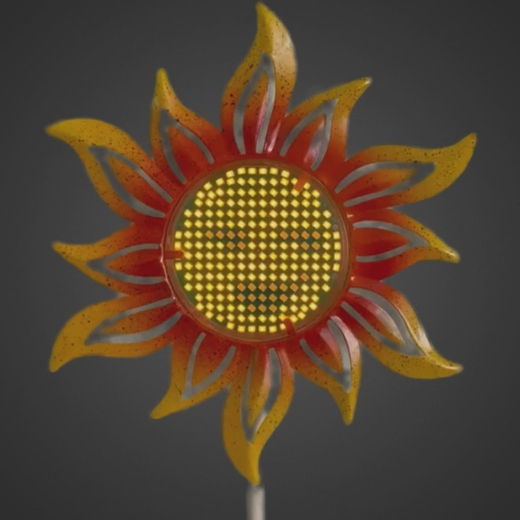 Video eines Gartensteckers „Sonnenblume“ mit Solar‑LED; das Smiley‑Gesicht in der Blütenmitte ändert sichtbar seine Darstellung.