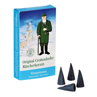Verpackung der Original Crottendorfer Räucherkerzen ‚Wintertraum‘ mit winterlicher Illustration: Ein Mann in grüner Kleidung und schwarzem Hut hält einen Spazierstock, im Hintergrund ist eine verschneite Landschaft mit Kirche zu sehen. Auf der Verpackung steht ‚Original Crottendorfer Räucherkerzen‘, darunter der Duftname ‚Wintertraum‘. Vor der Schachtel liegen vier rote, kegelförmige Räucherkerzen.