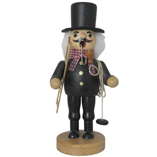 Ein Räuchermann "Schornsteinfeger" steht auf einem runden Sockel. Er trägt schwarze Kleidung mit goldenen Knöpfen, einen hohen schwarzen Hut, eine rot-weiß karierte Halsbinde und hat weißes Haar. In der Hand hält er einen Besen und ein Seil mit Gewicht, im Mund steckt eine Pfeife.