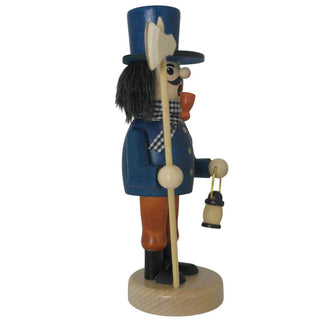 Ein Räuchermann "Nachtwächter" steht auf einem runden Sockel. Er trägt einen blauen Mantel mit goldenen Knöpfen, einen blaue Zylinder, braune Hose und schwarze Stiefel. Der bärtige Mann hat ein Pfeifchen im Mund, hält eine Axt in der einen Hand und eine kleine Laterne in der anderen. Seitenansicht