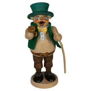 Holzfigur eines dickbäuchigen Gärtners mit grünem Hut und Weste, gelber Fliege und braunen Hosen. Die Figur hält eine Pfeife in der rechten Hand und einen Stock in der linken Hand. Sie steht auf einem runden Holzsockel.