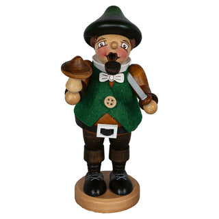 Das Bild zeigt ein Räuchermännchen „Pilzsammler“, 16 cm groß. Es ist eine  Holzfigur, die einen Pilzsammler darstellt. Die Figur trägt einen grünen Hut und eine grüne Weste mit einem weißen Hemd darunter. In der rechten Hand hält sie einen großen Pilz und in der linken Hand ein Messer. Die Figur steht auf einem runden Holzsockel und hat schwarze Schuhe an.
