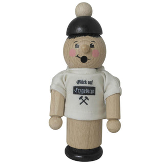 Ein traditioneller Räuchermann aus dem Erzgebirge, gefertigt aus Holz. Er trägt ein weißes T-Shirt mit der Aufschrift "Glück auf Erzgebirge" und zwei gekreuzten Hämmern darunter. Sein Gesicht ist freundlich bemalt, und er hat eine schwarze Mütze auf dem Kopf. Frontansicht