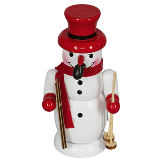 Ein Räuchermännchen als weißer Schneemann aus Holz, der 10 cm groß ist. Der Schneemann trägt einen roten Zylinderhut und einen roten Schal. In der linken Hand hält er zwei Skier und in der rechten Hand zwei Skistöcke. Das Gesicht des Schneemanns hat schwarze Augen, eine rote Karottennase und ein freundliches Lächeln.