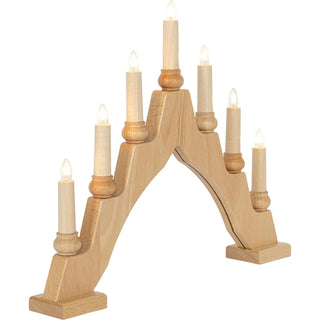 Ein Schwibbogen aus hellem Holz mit sieben elektrischen Kerzen, symmetrisch angeordnet – drei auf jeder Seite und eine mittig oben. Die kleinen Leuchtmittel ähneln traditionellen Wachskerzen und spenden warmes Licht. Der flache Sockel sorgt für einen stabilen Stand auf ebenen Flächen.