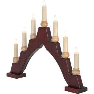 Ein bogenförmiger Schwibbogen mit sieben elektrischen Kerzen. Die mittlere Kerze ist am höchsten, die anderen sind symmetrisch abfallend angeordnet. Der Sockel ist dunkelbraun, die Kerzen sind hell und mit kleinen, leuchtenden Glühbirnen versehen.