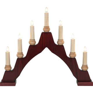 Ein bogenförmiger Schwibbogen mit sieben elektrischen Kerzen. Die mittlere Kerze ist am höchsten, die anderen sind symmetrisch abfallend angeordnet. Der Sockel ist dunkelbraun, die Kerzen sind hell und mit kleinen, leuchtenden Glühbirnen versehen.