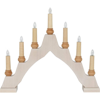 Ein Schwibbogen aus hellem Holz mit sieben elektrischen Kerzen, die auf kleinen Holzhaltern stehen. Die Kerzen sind symmetrisch angeordnet – die mittlere ist am höchsten, die anderen nehmen nach außen hin ab. Jede Kerze hat eine klare Glühbirne.
