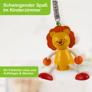 Ein hängendes Holzspielzeug in Form eines fröhlichen Löwen mit gelbem Körper, orangefarbener Mähne, roten Schuhen und lächelndem Gesicht. Der Löwe ist an einer Metallfeder befestigt. Im Bild steht: „Schwingender Spaß im Kinderzimmer“ und „Ein fröhlicher Löwe zum Aufhängen & Staunen“.