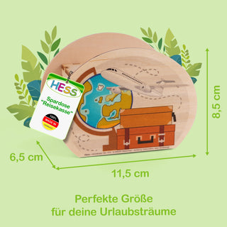Ovale Spardose aus Holz mit den Maßen 11,5 cm breit, 8,5 cm hoch und 6,5 cm tief. Auf der Vorderseite sind ein Globus, ein Flugzeug und ein Koffer abgebildet – Symbole für Reisen und Urlaub. Ein Etikett trägt die Aufschrift: „HESS Spardose 'Reisekasse' 100% MADE IN GERMANY“. Im Hintergrund sind grüne Blätter zu sehen, darunter steht: „Perfekte Größe für deine Urlaubsträume“.