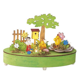 Auf der grünfarbenen Spieluhr befindet sich eine LED die mit 2 x AA Batterien betrieben wird. Zudem befinden sich noch kleine Küken, ein Blumenkind, ein Vogelhaus und viele frühlingshafte Akzente auf der Spieluhr