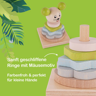 Ein Holz-Stapelspiel mit verschieden geformten und farbigen Ringen, die zu einem Turm gestapelt sind. Oben befindet sich ein Mäusekopf mit aufgemaltem Gesicht. Der Hintergrund ist grün mit Blattmotiven auf der linken Seite. Text im Bild: „Sanft geschliffene Ringe mit Mäusemotiv – Farbenfroh & perfekt für kleine Hände“.