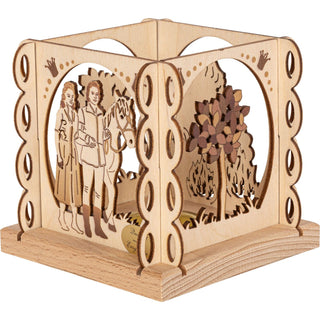 Der kleine hölzerne Teelichthalter in Natur ist quadratisch und mit mehreren Rundungen an den Außenseiten und mit verschiedenen Blenden versehen. Zu sehen ist hierbei das Zauberbäumchen und das Prinzenpaar mit Pferd. Mit einem Teelicht könnte man den Teelichthalter erhellen. Bild 4.