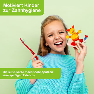 Ein Kind in einem blauen Pullover hält eine rote Zahnbürste in der linken Hand und ein Spielzeug in Form einer bunten Katze mit Zahnbürste in der rechten Hand. Der Hintergrund ist hellgrün. Im Bild steht oben links: „Motiviert Kinder zur Zahnhygiene“ und unten links: „Die süße Katze macht Zähneputzen zum spaßigen Erlebnis“.