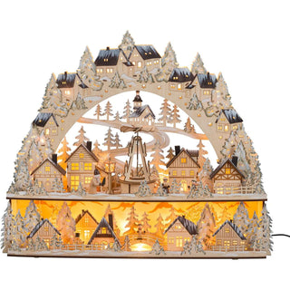 XL LED Lichterbogen Weihnachtsmarkt mit beweglicher Pyramide. Unzählige filigrane Details finden sich auf zwei Ebenen, beleuchtete Hütten, verschneite Bäume und gedrechselte Figuren zeigen die ganze Vielfalt handwerklichen Könnens. Highlight ist natürlich die bewegliche Pyramide im Zentrum, die von einem kleinen Motor angetrieben wird. Den Schwibbogen selbst zieren 25 LED-Lampen, die im Inneren platziert sind und für indirektes Licht sorgen.