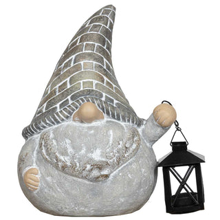 Dekorative Gartenfigur eines Wichtels in Steinoptik mit hohem spitzem Hut, rundem Körper und grauem Bart, der in der rechten Hand eine schwarze Laterne hält, freigestellt vor weißem Hintergrund.
