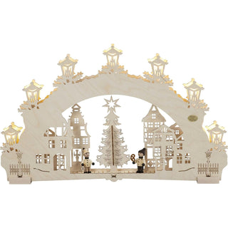 Hier ist ein 7-flammiger-3D Schwibbogen aus Holz dargestellt. Mittig steht ein festlich geschmückter Baum mit einer Sternenspitze. Auch sind die Schaufenster um den Marktplatz weihnachtlich hergerichtet. Besonders schön leuchten die Laternen um den Bogen. Ein besonderer Blickfang sind die bemalten plastischen Kinder.