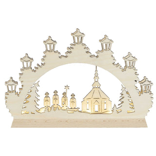 LED-Schwibbogen Mini „Kurrende“ aus naturfarbenem Holz mit traditioneller Weihnachtsszene. Das Motiv zeigt vier Kurrende-Sänger vor einer Kirche, eingerahmt von Tannenbäumen und sieben laternenförmigen Lichtpunkten. Die integrierte LED-Beleuchtung sorgt für warmes, stimmungsvolles Licht und hebt die filigranen Holzdetails hervor.