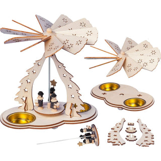 Weihnachtspyramide als Bastelset für 2 Teelichte. Der Bogen und die Flügel sind mit Sternen verziert. Auf der Pyramide sind 3 kleine Kurrendesänger. Link und recht auf dem Pyramidenboden befinden sich die Einsätze für die Teelichte.