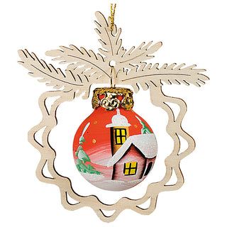 Christbaumschmuck "Abenddämmerung" zeigt eine rote Kugel mit einer handgemalten winterlichen Landschaft, Häuschen, umgeben von schneebedeckten Tannenbäumen. Die Kugel hängt an einem goldenen Aufhänger und ist von einer filigranen Holzverzierung in Form von Tannenzweigen und einem Kranz umrahmt.