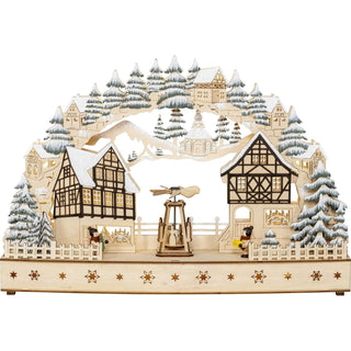 LED Lichterbogen mit Fachwerkhäuser und drehender Pyramide in der Mitte, umrahmt von grünfarbenen, beschneiten Winterbäumchen, kleinen Häuschen und der Seiffener Kirche