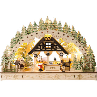 LED Lichterbogen mit Batteriefach und Timerfunktion. Auf dem Bogen befindet sich eine Weihnachtsbäckerei mit Winterkindern und einem Bäcker. Der Bogen, der diese Szene umschließt, ist mit grünen Bäumchen verziehrt. auf dem Sockel ist nochmals eine fillegrane Landschaft abgebildet.