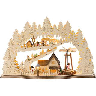 LED Lichterbogen Stadt mit beweglicher Pyramide. Ganz im Hintergrund schnauft eine Dampflock über das Viadukt, während im mittleren Bereich der Weihnachtsbaum per Schlitten über die Skipiste transportiert wird. Unten angekommen, wartet schon das dezent beleuchtete, traute Heim und bittet zum Weihnachtsfest. Die Szene wird von einem üppigen, verschneiten Winterwald überspannt.