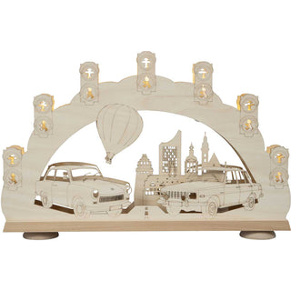 Der 7-flammige Schwibbogen mit 3D Effekt hat ein besonders schönes, an frühere (DDR-) Zeiten erinnerndes Motiv. Die Fahrzeuge Trabant und Wartburg - in den dargestellten Modellen - begleiteten die Menschen im Osten Deutschlands über viele Jahrzehnte und wecken Erinnerungen an Erlebtes in vergangenen Tagen. Im Hintergrund steigt über die Stadt Leipzig ein Heißluftballon auf. 7 Lichtsignalanlagen mit Ampelmännchen umranden den Bogen. Bild 1.