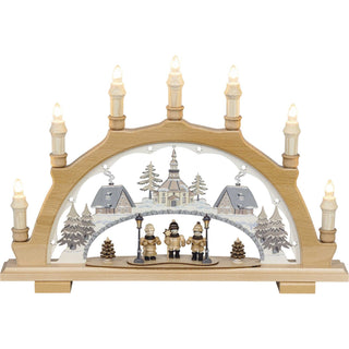 Der 7-flammige Schwibbogen Sternsinger aus Holz ist ein originales erzgebirgisches Handwerksprodukt. Im Bogen ist das beschneite Weihnachtsdorf Seiffen in dezenten Pastelltönen dargestellt. Unter dem kalten Sternenhimmel stimmt der kleine Kinderchor die Weihnachtszeit mit schönen Liedern ein.