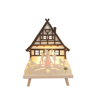 Standleuchte Waldhaus aus Holz. Indirekt durch LED beleuchtet zeigt zentral Kinder, die Schneemannbauen, das Hauptmotiv ist eine Wandhaus im Hintergrund.