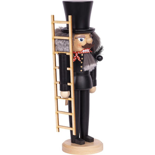 Dieser Schornsteinfeger ist ein in schwarz mit roten Halstuch bemalter Nussknacker. Gezeigt hier im Seitenprofil. Er hat eine Leiter, einen Feger und weiches Haar. In 2 Größen ist die Figur erhältlich. Bild 3.