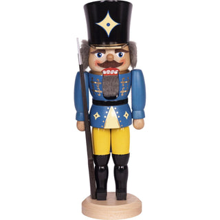 Dieser Soldat ist ein in blau-gelb-weiß-schwarz-golden bemalter Nussknacker. Er trägt einen schwarz-goldenen Hut,  schwarze Stiefel, eine blau-gelbe Uniform, ein Gewehr und weiches graues Haar. In 2 Größen und 3 Farben ist die Figur erhältlich. Bild 7.