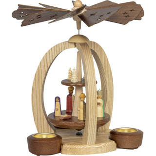 Diese echt erzgebirgisch 2-stöckige-Premium-Weihnachtspyramide aus Holz gibt es in 2 Variationen. Auf der unteren Etage ist hier das Motiv Christi Geburt mit bunten gedrechselten Figuren dargestellt. Die obere Platte zeigt mehrere kleine Spanbäumchen in verschiedenen Größen und Holvarianten. Mit dezenten hellen und dunklen Akzenten, ist diese Pyramide ein echter Blickfang. Bild 2.