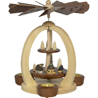 Diese echt erzgebirgische 2-stöckige-Premium-Weihnachtspyramide aus Holz gibt es in 2 Variationen. Auf der unteren Etage ist das Seiffener-Weihnachtsdorf mit der Kirche und zwei gedrehten Spanbäumchen dargestellt. Die obere Platte zeigt vier weitere Spanbäumchen in verschiedenen Größen. Mit dezenten hellen und dunklen Akzenten, ist diese Pyramide ein echter Blickfang. Bild 1.