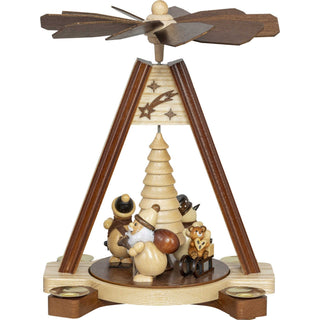 Aus lasiertem Holz und mit vier niedlichen, abgerundeten Figuren auf dem Drehteller ist diese Pyramide ein echter Blickfang. Ein Weihnachtsmann mit Wuschelbart und ein Schneemann, ein Skifahrer und ein Teddybär mit Schlitten drehen sich um einen gedrechselten großen Baum. In Natur aber mit schattierten Akzenten verfeinert. Mit 4 Pyramidenkerzen kann die Pyramide mittels Wärmestrom und den schrägen Flügeln um die eigene Achse drehen. In 2 Farben ist dieses Modell erhältlich. Bild 1.