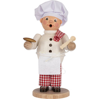 Hier sieht man einen 23cm-großen Bäcker mit einem Löffel und Backware in der Hand. Er trägt eine rot-weiß-karierte Hose. Weis ist auch seine Mütze, die Schürze und das Hemd. Passend zur Hose hat er ein Tuch auf der Schulter. abgelegt. Das Räuchermännchen hebt man von den Beinen ab, um eine Räucherkerze abzulegen. Damit hat man zusätzlich einen besinnlichen Weihnachtsduft im Raum.