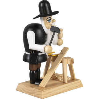Farbiges Räuchermännchen im Motiv eines Zimmermannes. In der einen Hand hält er einen Hammer und in der anderen seine Pfeife. Maßstab, Holzbock, Brett und Spähne sind auch auf dem Sockel mit abgebildet._2