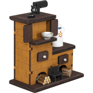 Der Räucherofen aus Massivholz besteht aus 2 Ebenen. Auf der oberen Ebene sitzt eine kleine, schwarze Katze. Auf der unteren Ebene steht eine Kaffeekanne. Vor dem Ofen liegen 2 Holzstapel und in der Mitte, vor dem Ofen steht noch eine kleines Bänkchen_3