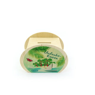 Rechteckige, hölzerne Spardose mit ovalem Schild auf der Vorderseite. Das Schild zeigt eine tropische Szene mit Palmen, einem Schmetterling und dem Schriftzug „Urlaubskasse“. Unten links ist das Logo „HESS“ zu sehen.