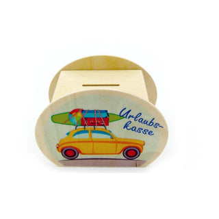 Hölzerne Spardose mit Münzschlitz oben. Auf der Vorderseite ist ein gelbes Auto mit Surfbrett und rotem Koffer auf dem Dach abgebildet. Daneben steht in blauer Schrift das Wort „Urlaubskasse“.